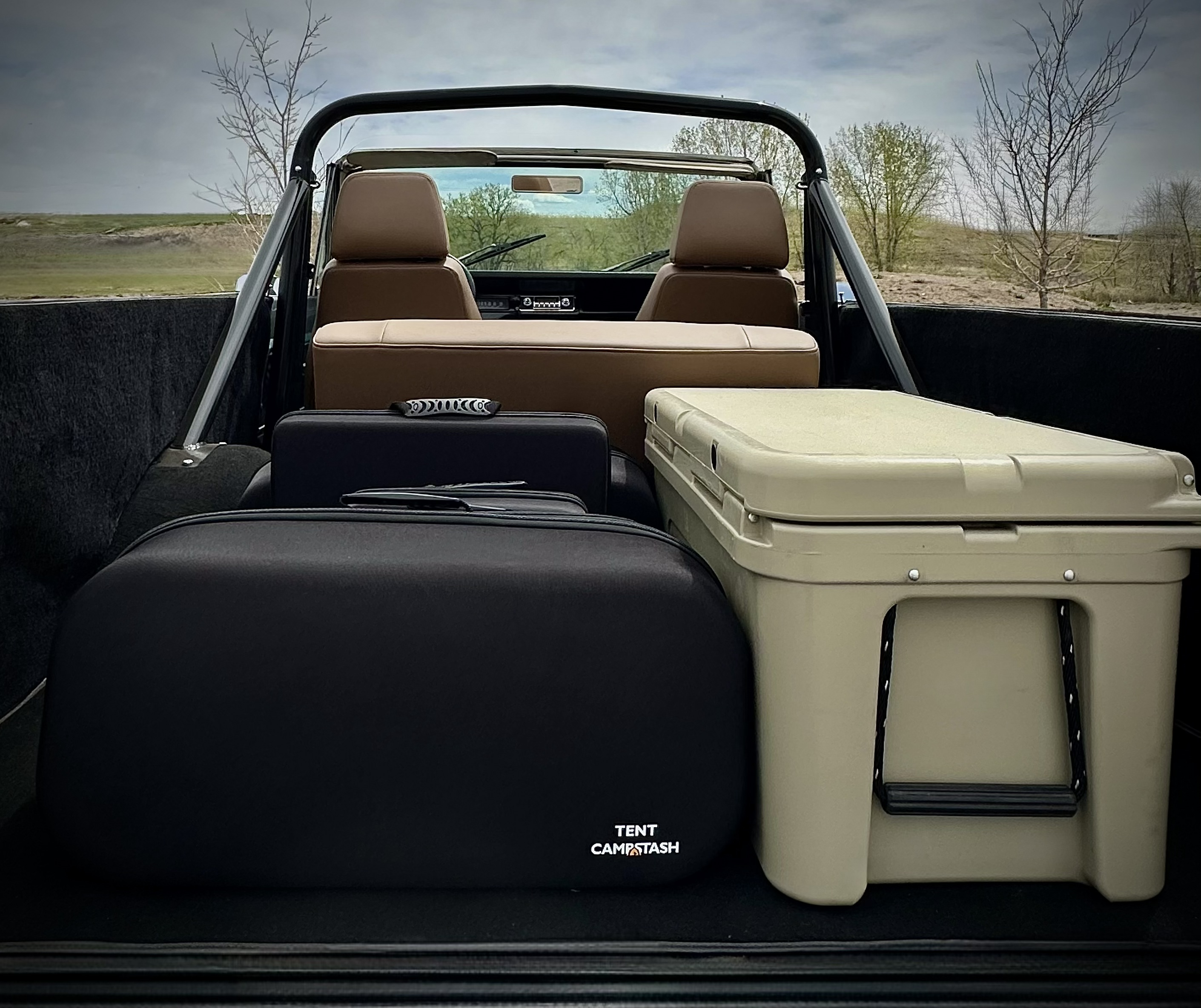 Campstash case packed in truck bed next to cooler