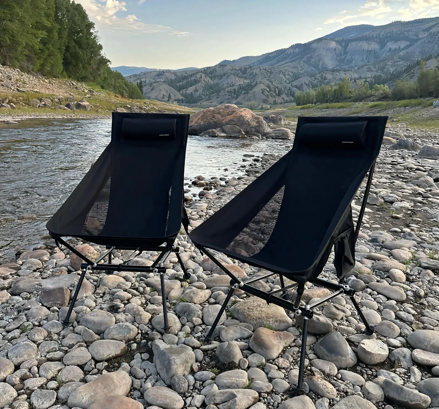 Two black Campstash chairs set up beside a mountain river